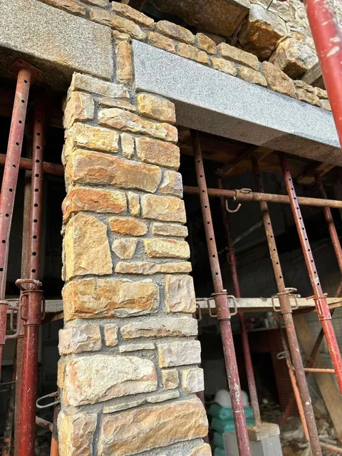 Détail du chantier : pierres appareillées et linteaux en granit, maintenus par des étais