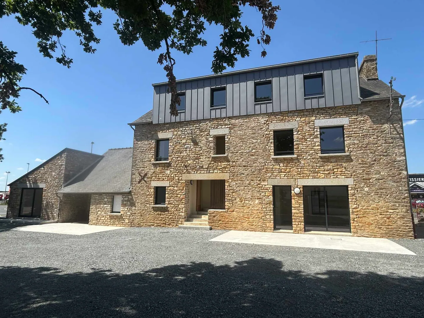 Façade en pierre et surélévation en zinc d’un bâtiment rénové par Sirouet Maçonnerie